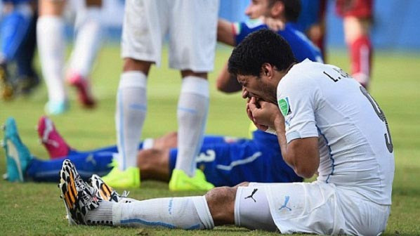 Suarez ôm lấy hàm răng của mình vẻ rất đau đớn sau pha va chạm với Chiellini