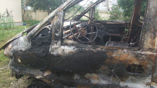 Chiếc xe bán tải đã cháy trụi và biến dạng sau cú tông liên hoàn vào bờ tường. Ảnh: Đức Hùng.