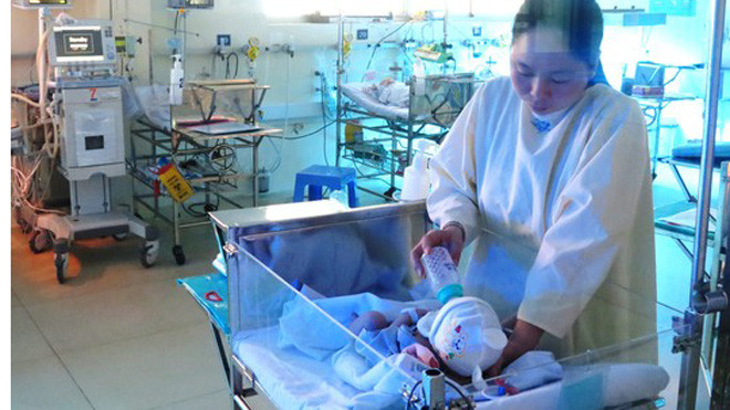 Bé Huy đang được dì cho bú sữa.