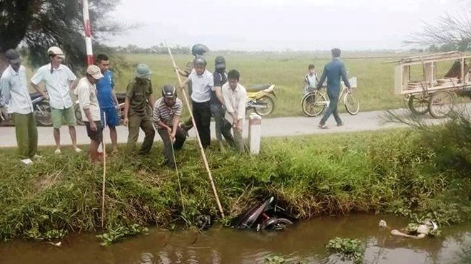 Người dân trục vớt thi thể và xe máy của nạn nhân lên bờ. Ảnh. Đ.H