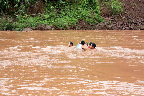 Các bậc phụ huynh liều mình đưa con qua suối kịp khai giảng năm học mới. Ảnh: baolaichau.vn