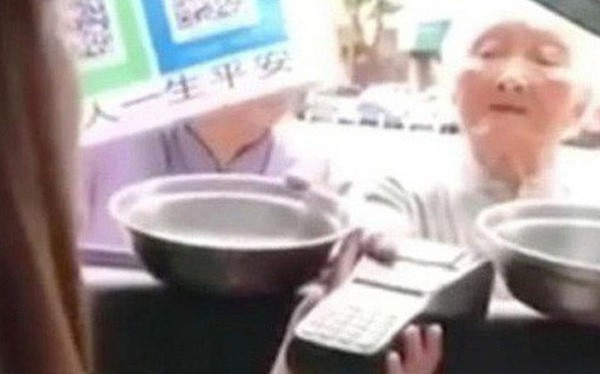 Một cụ bà ăn xin bằng smartphone