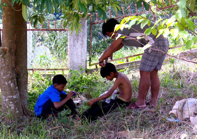 Thầy Sứ đang cắt tóc cho các em học sinh của trường