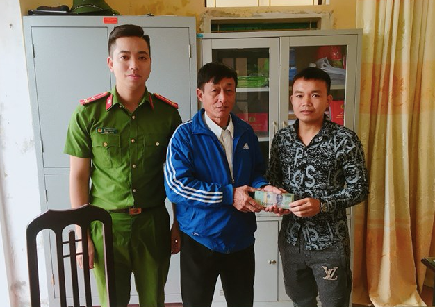 Anh Lương Văn Phú (bìa phải) trả lại 38 triệu đồng đã nhặt được trên đường cho ông Bùi Xuân Hỗ - Ảnh: Hoàng Long