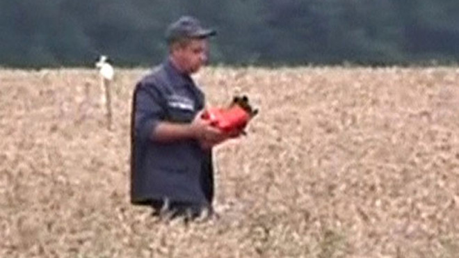 Hình cắt trong video cho thấy một nhân viên cứu hộ cầm hộp đen trong tay. Ảnh: Reuters.