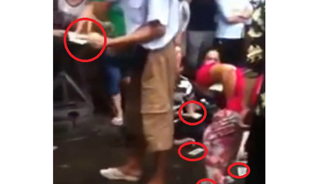 Người đàn ông rải từng nắm tiền trước chợ