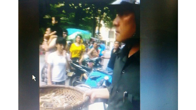 Cán bộ đội trật tự cầm rổ tôm tít đưa ra xe trước sự chứng kiến của rất nhiều khách du lịch