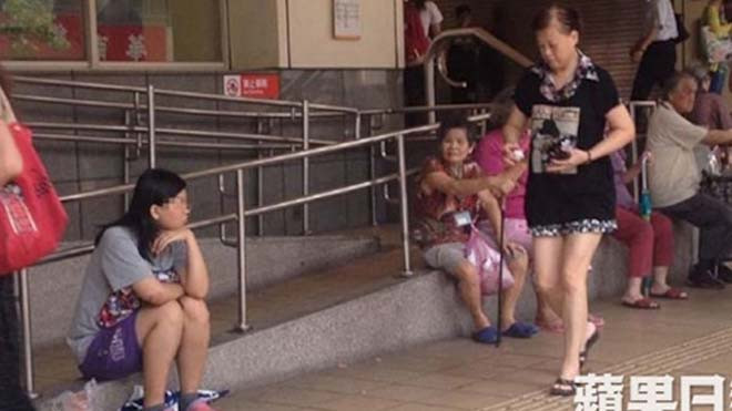 Su ăn mặc chỉnh tề ngồi bên chiếc bát ăn xin của mình. 