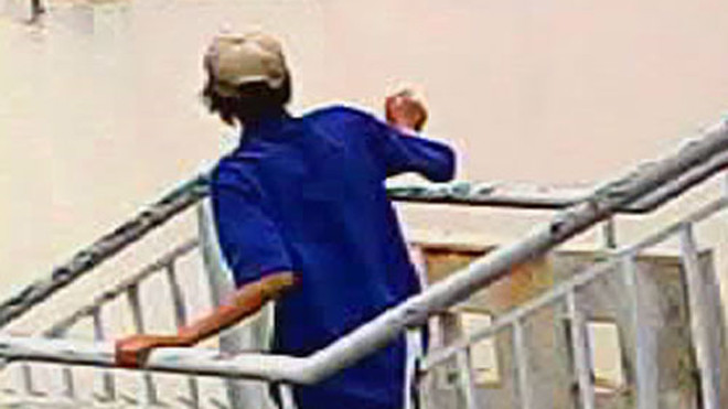 Một con nghiện đang vứt kim tiêm trên mái tôn Bệnh viện Ung bướu - Ảnh: Đức Tiến (Thanh Niên)