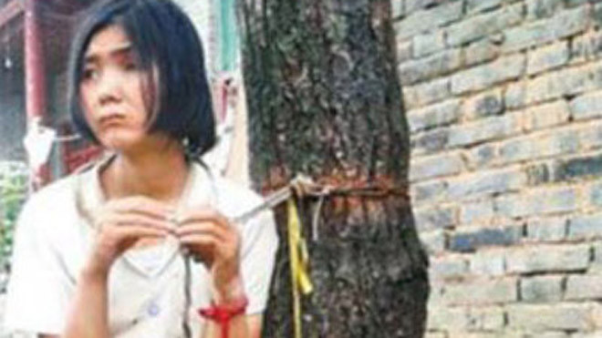 Zhang Yanrong bị trói vào cây. Ảnh: Shanghaiist