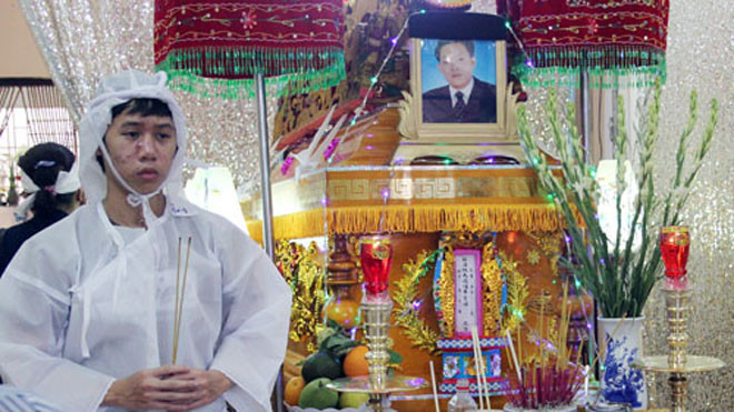 Con trai lớn của ông Chín bên linh cữu cha. Ảnh: An Nhơn