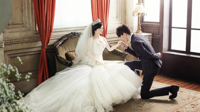 Chú rề quỳ gối hôn tay cô dâu. Ảnh: YorkBBS.ca