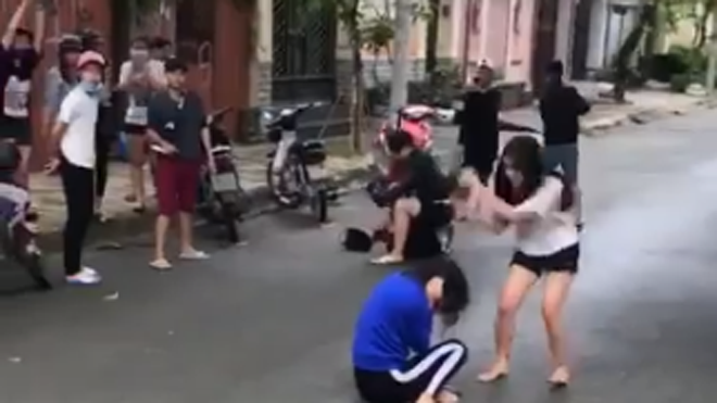 Nữ sinh áo tráng dùng mũ bảo hiểm đánh tới tấp vào đầu nữ sinh áo xanh trước chứng kiến của nhiều người 