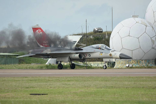 Khói đen tiếp tục bốc ra từ động cơ sau khi tiêm kích hạ cánh. Ảnh: CNA.