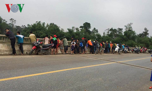 Người dân tập trung trên cầu Địa Lợi theo dõi việc tìm kiếm thầy giáo H.