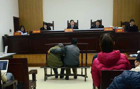 Bị cáo Nguyễn Danh Vĩnh phải có người ngồi dìu đỡ trước vành móng ngựa. Ảnh: Hoàng Cư.