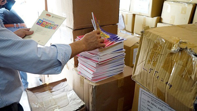 Nhà chức trách kiểm tra số sách in lậu. Ảnh: Phan Anh.