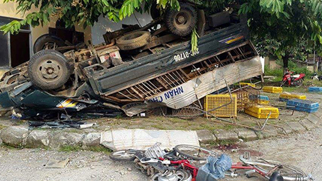 Xe tải gây tai nạn bẹp dúm phần đầu, lật ngửa trên vỉa hè, hai chiếc xe đạp của học sinh cũng bị hư hỏng nặng. Ảnh: CTV