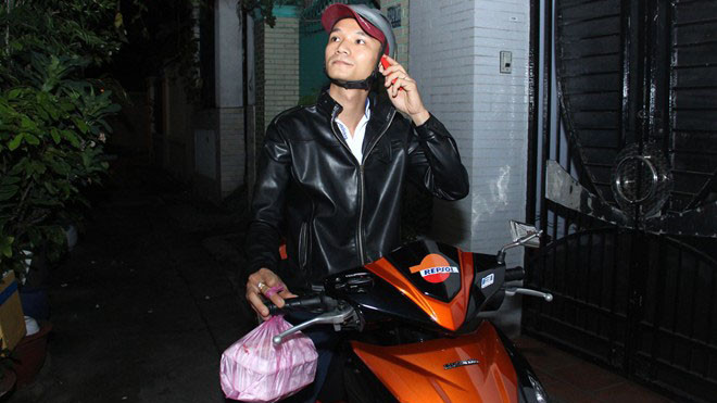 Shipper Nguyễn Thanh Hùng đang gọi điện giao đồ ăn cho một khách hàng nằm trong một hẻm vắng ở quận 4 vào lúc 2h. Ảnh: Zen Nguyễn.