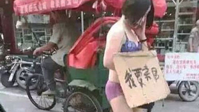 Cô Wang Ni với tấm biển "tôi bán cơ thể mình" trên cổ (Ảnh: Mirror)