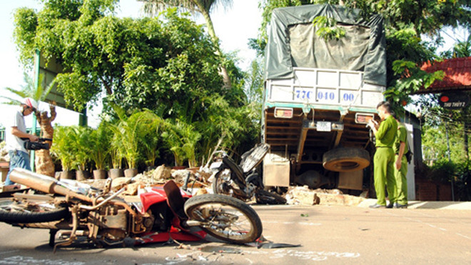 Hai xe máy bị xe tải cán nát. Ảnh: Kh.Uyên.