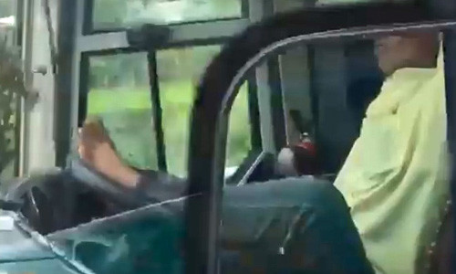 Tài xế gác chân lên vô lăng để lái xe - Ảnh cắt từ clip