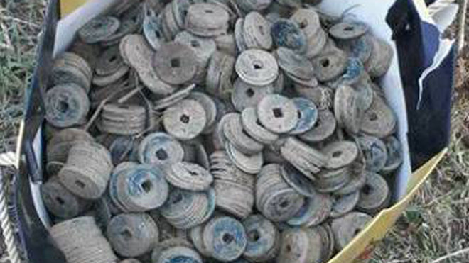28 kg tiền xu cổ được đựng trong hũ sành nằm sâu dưới ruộng lúa khoảng 25 cm. Ảnh: V.T