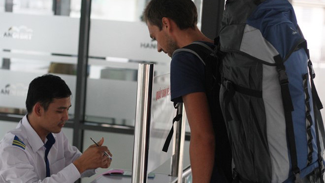 Một vị khách nước ngoài lấy vé buýt nhanh tại bến Kim Mã. Ảnh: Văn Chương.