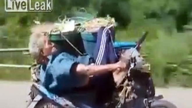 Cụ ông vừa nằm vừa điều khiển xe máy