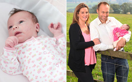 Bé Poppy lúc 14 ngày tuổi và bố mẹ. Ảnh: Swns.com.