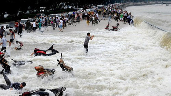 Trong khi người người bỏ chạy, xe cộ bị cuốn trôi thì anh chàng này vẫn "sống chết mặc bay". 