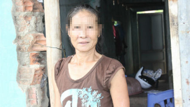 Chị Nguyệt trong căn nhà tường gạch loang lổ.