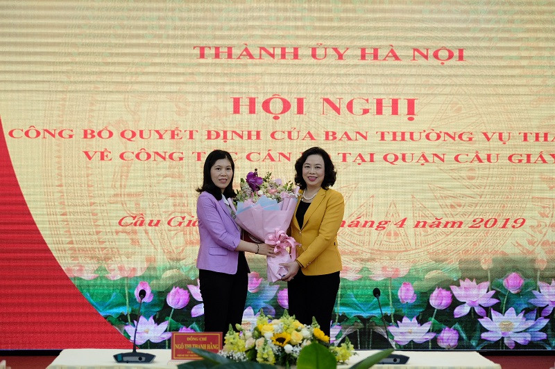 Phó Bí thư Thường trực Thành ủy Ngô Thị Thanh Hằng trao quyết định và tặng hoa chúc mừng tân Bí thư Quận ủy Cầu Giấy Trần Thị Phương Hoa.
