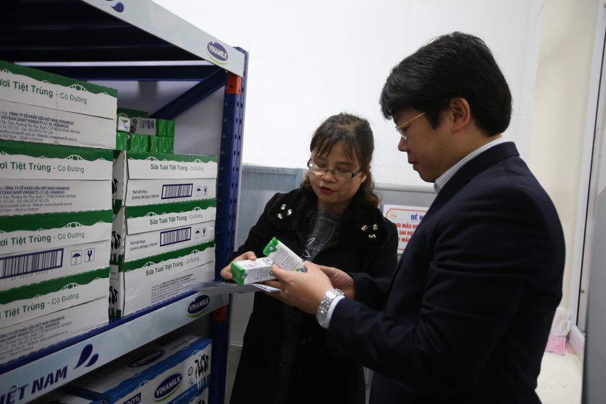 Thầy cô giáo tại một điểm trường tiểu học Hà Nội cẩn thận kiểm tra chất lượng sữa trước giờ xuất sữa cho học sinh tham gia chương trình uống sữa học đường