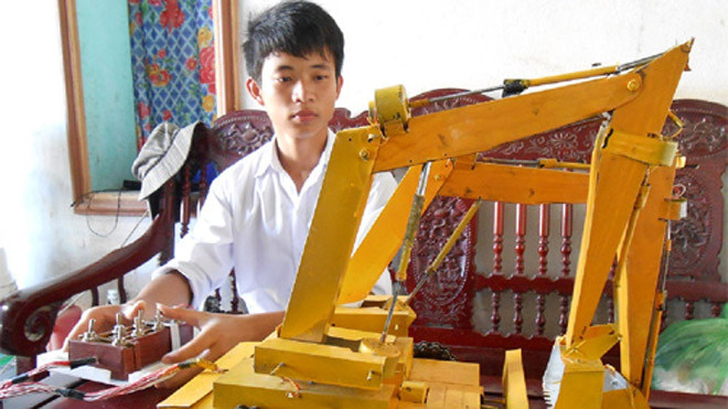 Phát đang vận hành chiếc máy cẩu hai tay múc bán tự động điều khiển từ xa - Ảnh Nhật Linh 