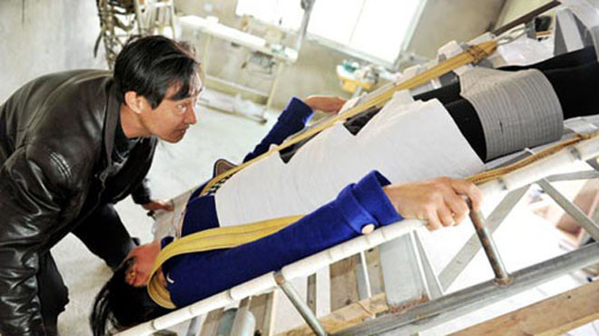 Vợ ông Châu có thể yên tâm dốc ngược đầu, "trồng cây chuối" chữa bệnh. Ảnh: CYOL