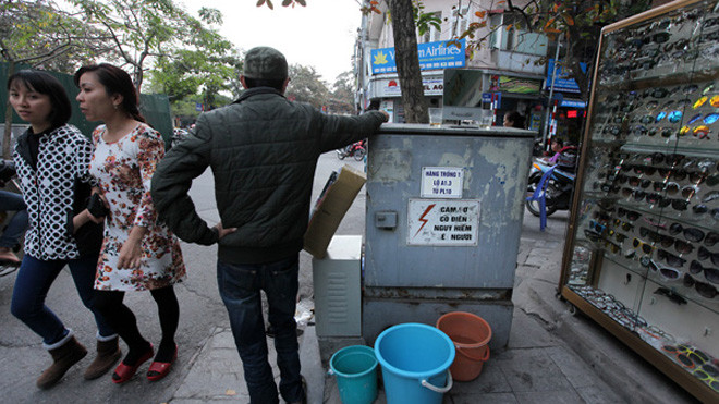Biển cảnh báo "Nguy hiểm chết người" trên hộp điện này không có ý nghĩa gì với người đàn ông này (Ảnh chụp tại phố Lương Văn Can).