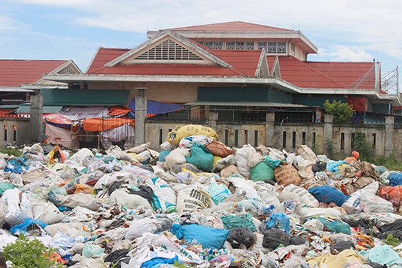 Rác chất thành đống, không được che chắn ngay sau chợ Hòa Ninh bốc mùi hôi thối ảnh hưởng đến cuộc sống người dân xung quanh.