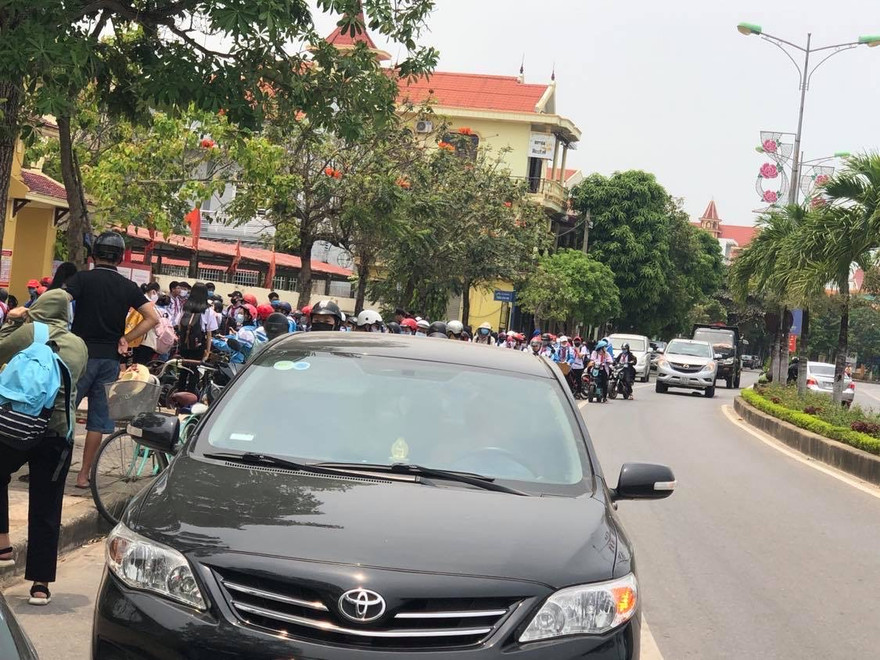 Hàng trăm học sinh đứng tràn xuống lòng đường trong khi chờ mở cổng trường