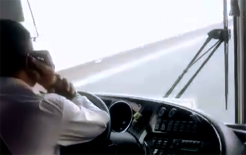 Tài xế xe khách liên tục sử dụng điện thoại và dùng cùi chỏ để lái xe chạy trên cao tốc Hà Nội - Hải Phòng. Ảnh: Cắt từ clip