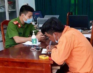 Đối tượng giả danh thợ điện đang viết lời khai tại cơ quan công an.