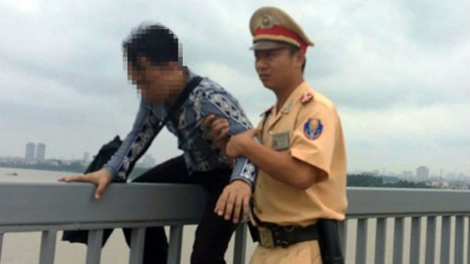 Lực lượng CSGT giữ và đưa thanh niên định nhảy cầu vào nơi an toàn​.