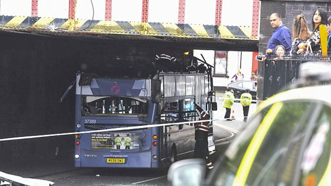 Xe buýt bị mất phần mái sau khi đi dưới cầu vượt thấp. Ảnh: Mercury Press