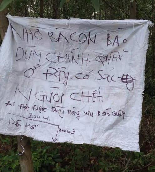 Chiếc bao gai màu trắng, ghi dòng chữ: "Nhờ bà con báo dùm chính quyền, ở đây có xác người chết. Ai đọc được dòng này xin báo giúp".