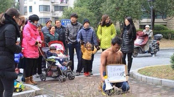 Người đàn ông quỳ gối trước khu nhà vợ con mình ở để xin lỗi.