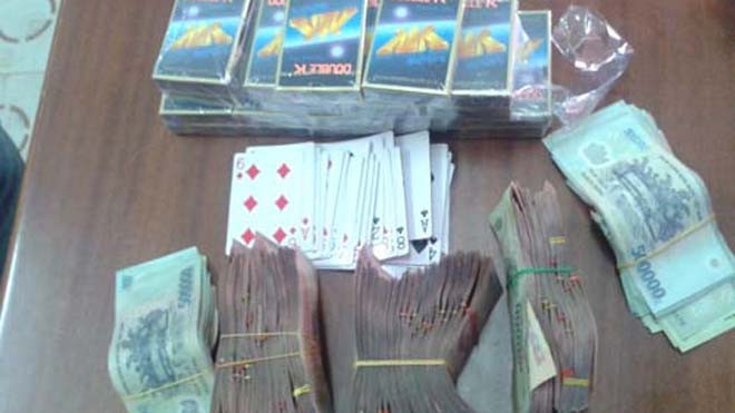 Hơn 200 triệu đồng và hàng chục bộ bài của các con bạc bị thu giữ. Ảnh: Hải Bình.