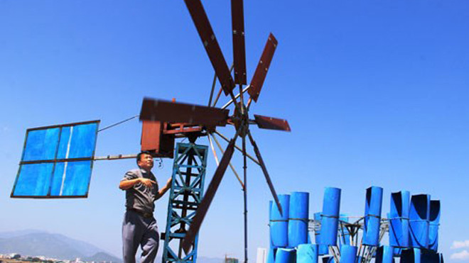 Ông Nguyễn Đức Tuấn bên hệ thống điện gió tự chế tạo - Ảnh: Nguyễn Chung