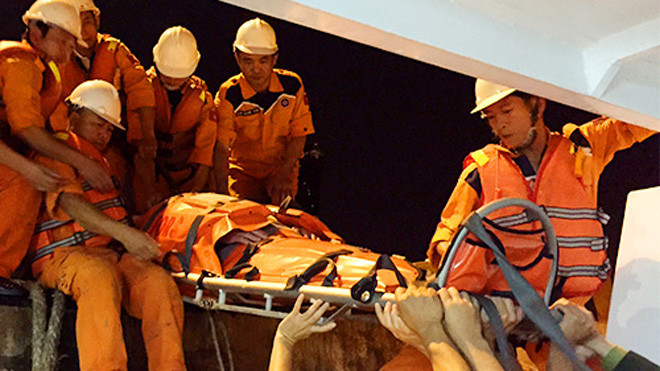 Các thuyền viên tàu SAR 412 đưa ông Ross lên bờ. Ảnh: Ngọc Trường.