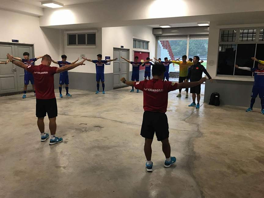 Thày trò HLV Hữu Thắng phải rút vào hành lang sân Universiti Malaya để tập tạm, tránh cơn mưa như trút nước chiều nay. Ảnh ĐOÀN NHẬT 