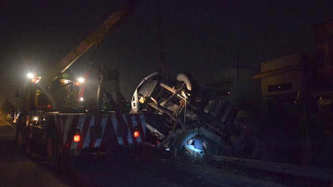 Xe ben lật ngang dưới mương nước sau cú tông xe máy.